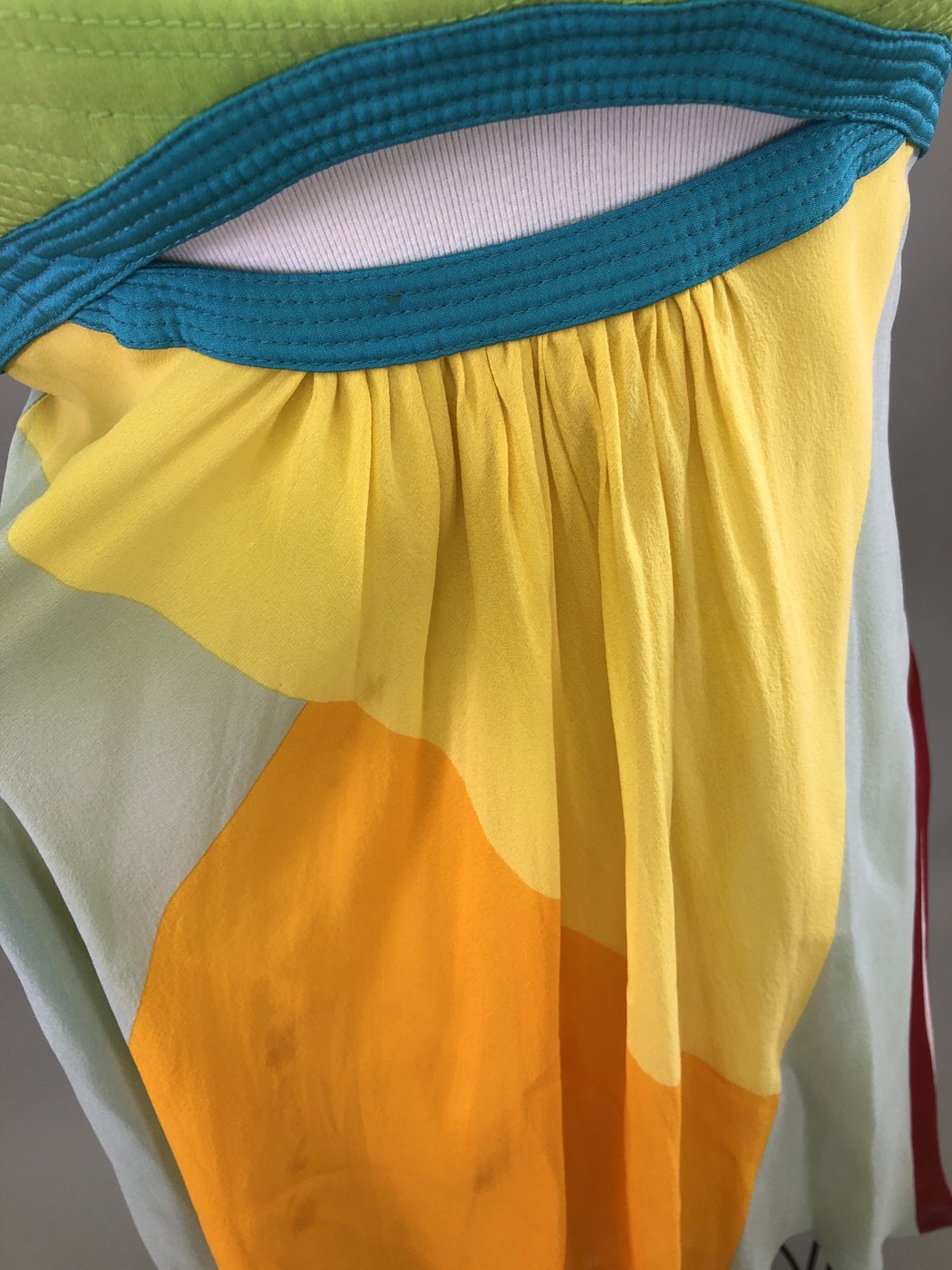 Before cleaning: staining on the yellow and orange silk panels below the turquoise bodice band of the Versace dress